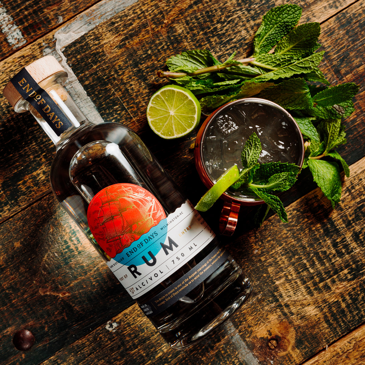 Port of Entry Rum with a mint and lime cocktail on a wooden table, top view