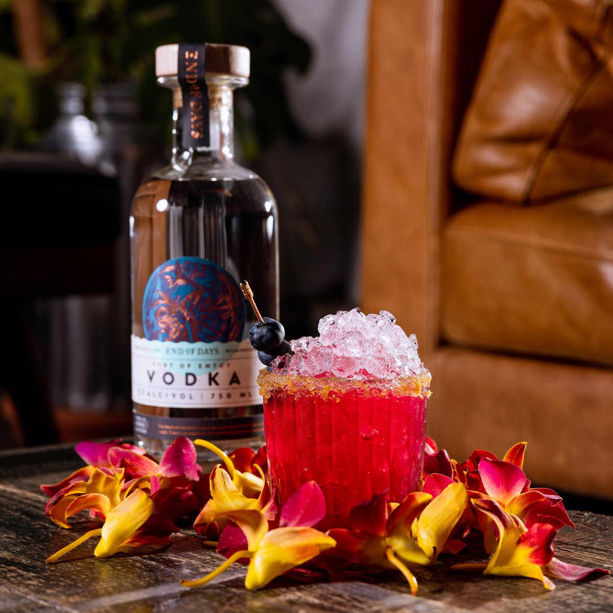 Port of Entry Vodka beside a pink cocktail garnished with tropical flowers