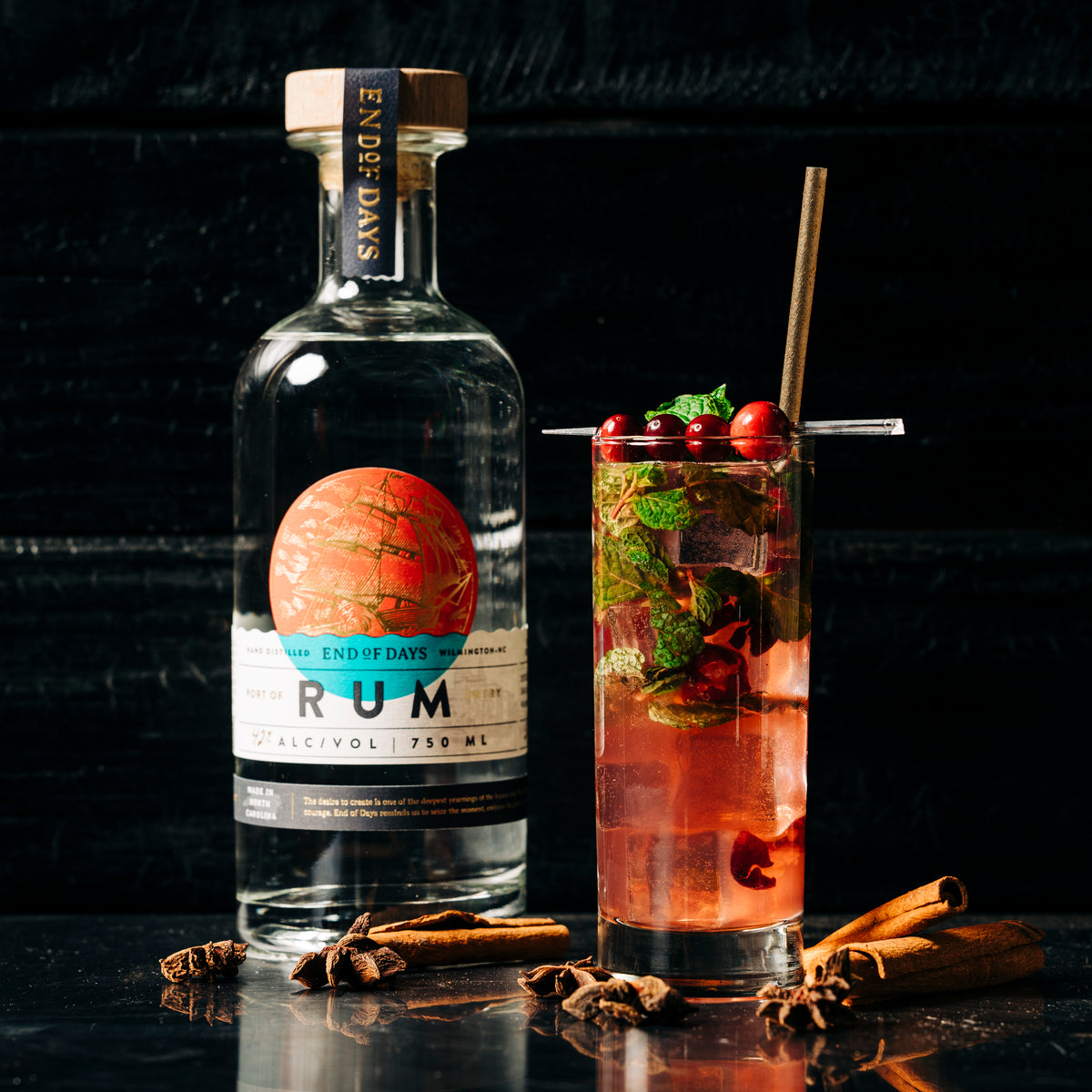 Port of Entry Rum bottle beside a berry mojito cocktail