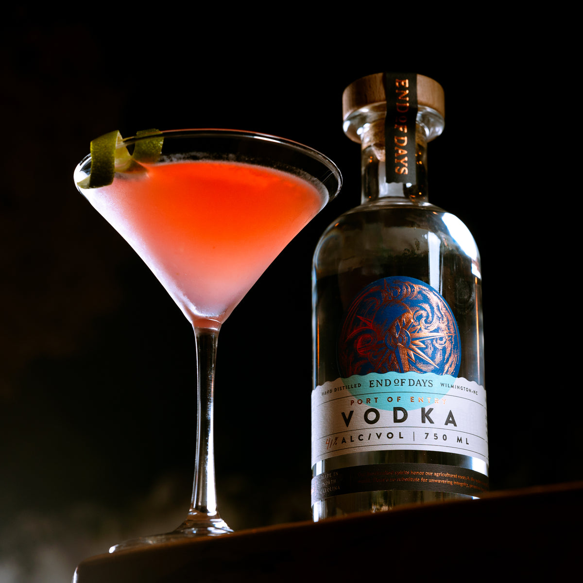 Cosmopolitan in a martini glass beside a bottle of Port of Entry Vodka